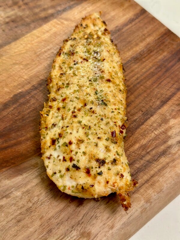 Cooked air fryer parmesan crusted chicken on cutting board