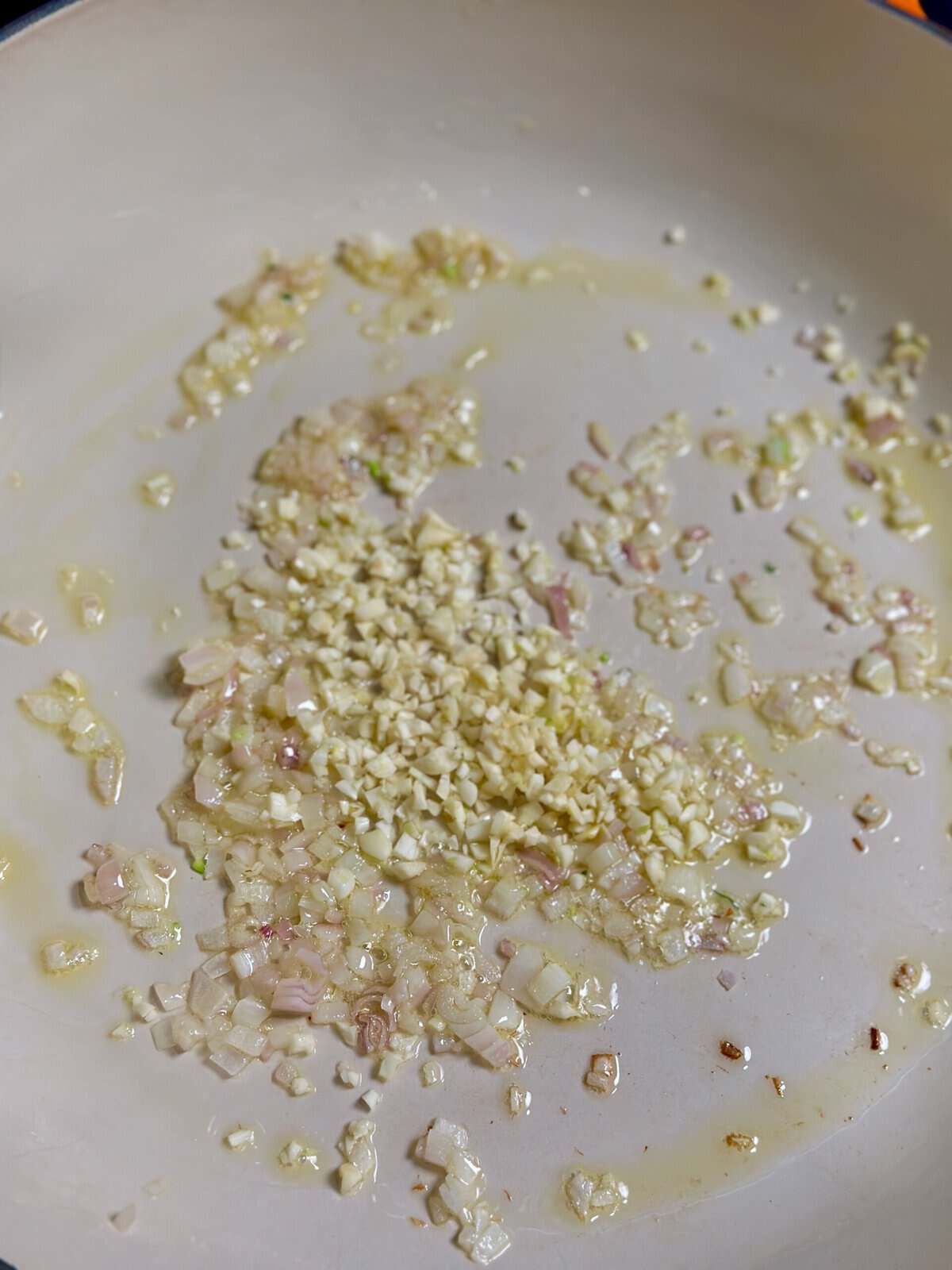 A pan with chopped shallots and garlic.