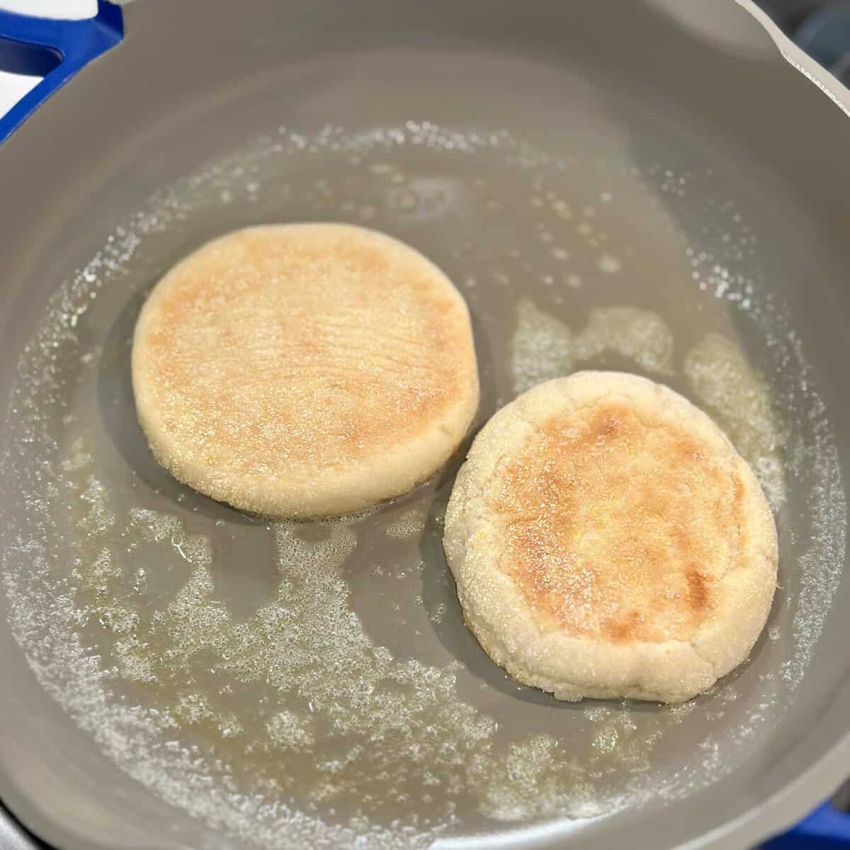 A pan with two english muffin halves