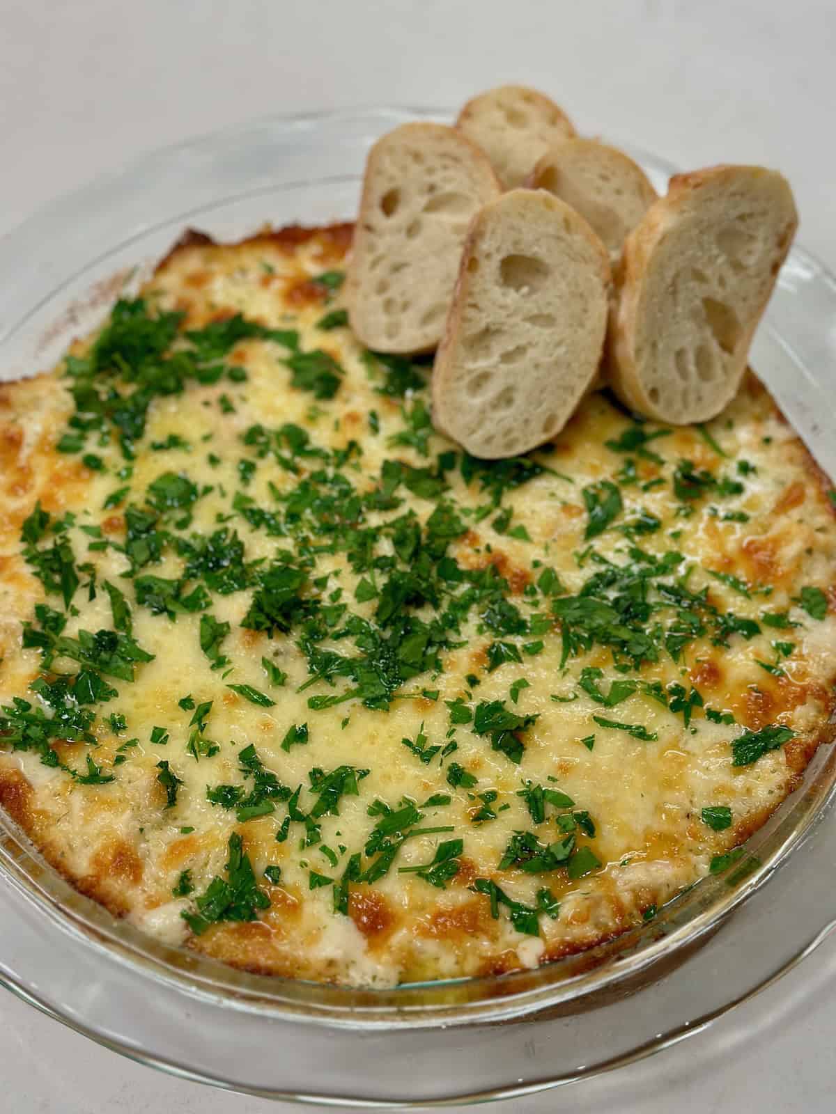 Chicken alfredo dip served with toasted bread for dipping.