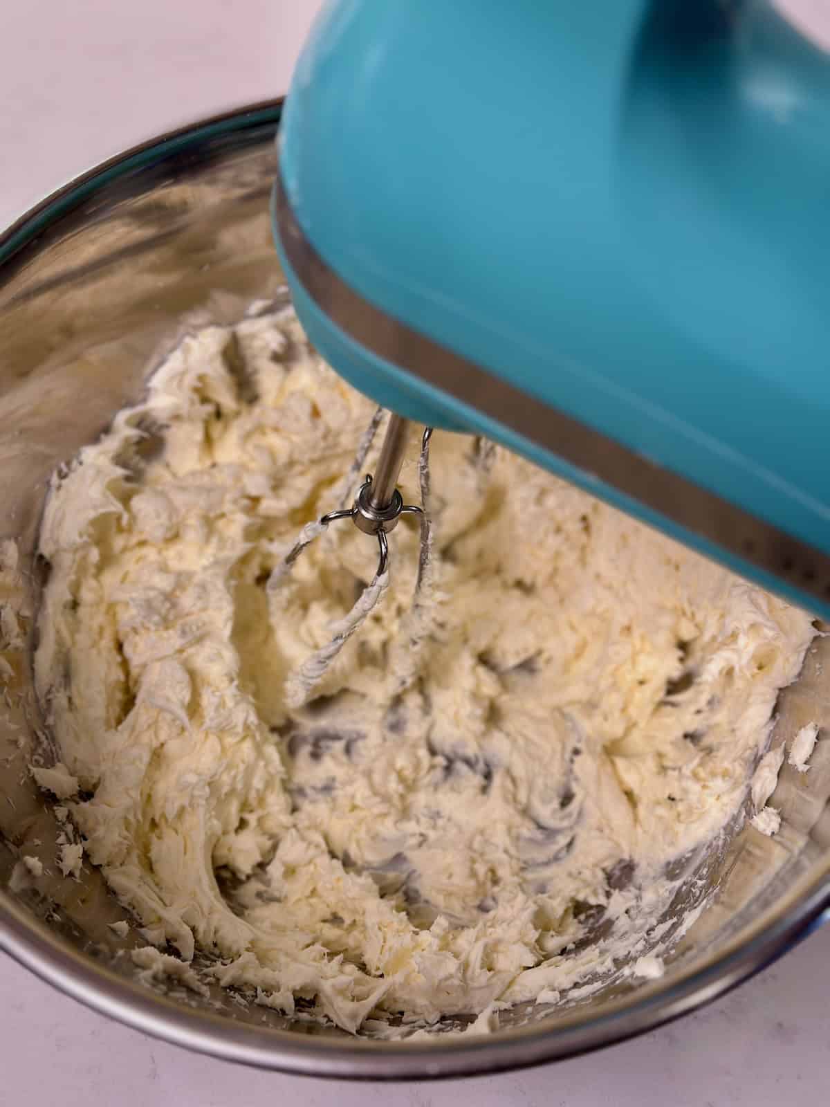 Hand mixer creaming butter and brown sugar together.