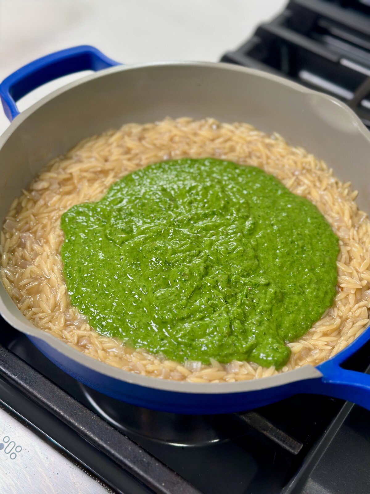 Cooked orzo and green goddess sauce in pan