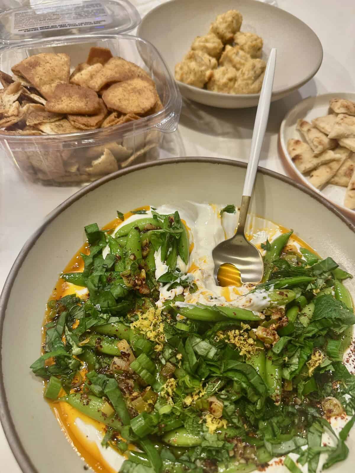 table with scallion yogurt dip, pita, and pita chips