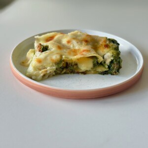 Slice of green lasagna on plate.