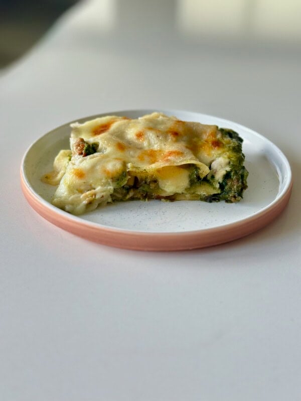 Slice of green lasagna on plate.