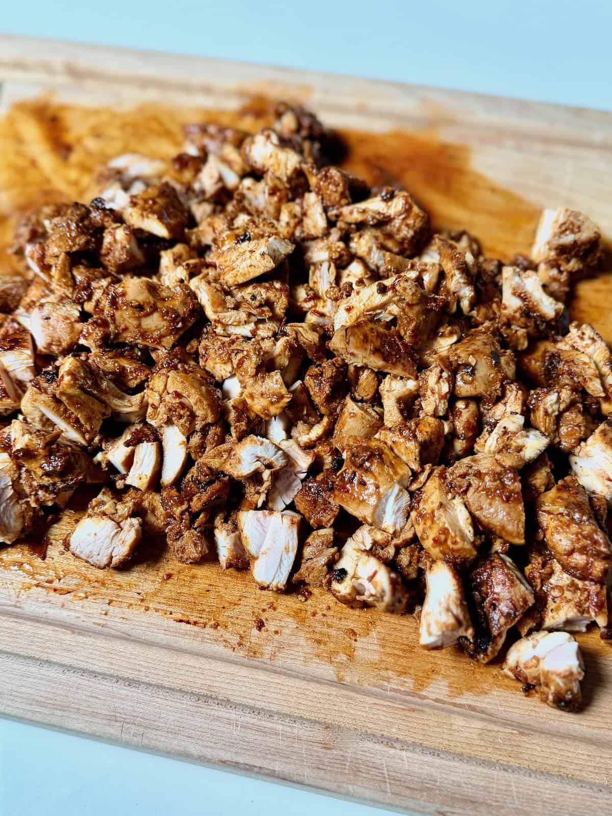 Chipotle copycat chicken chopped into pieces on cutting board.