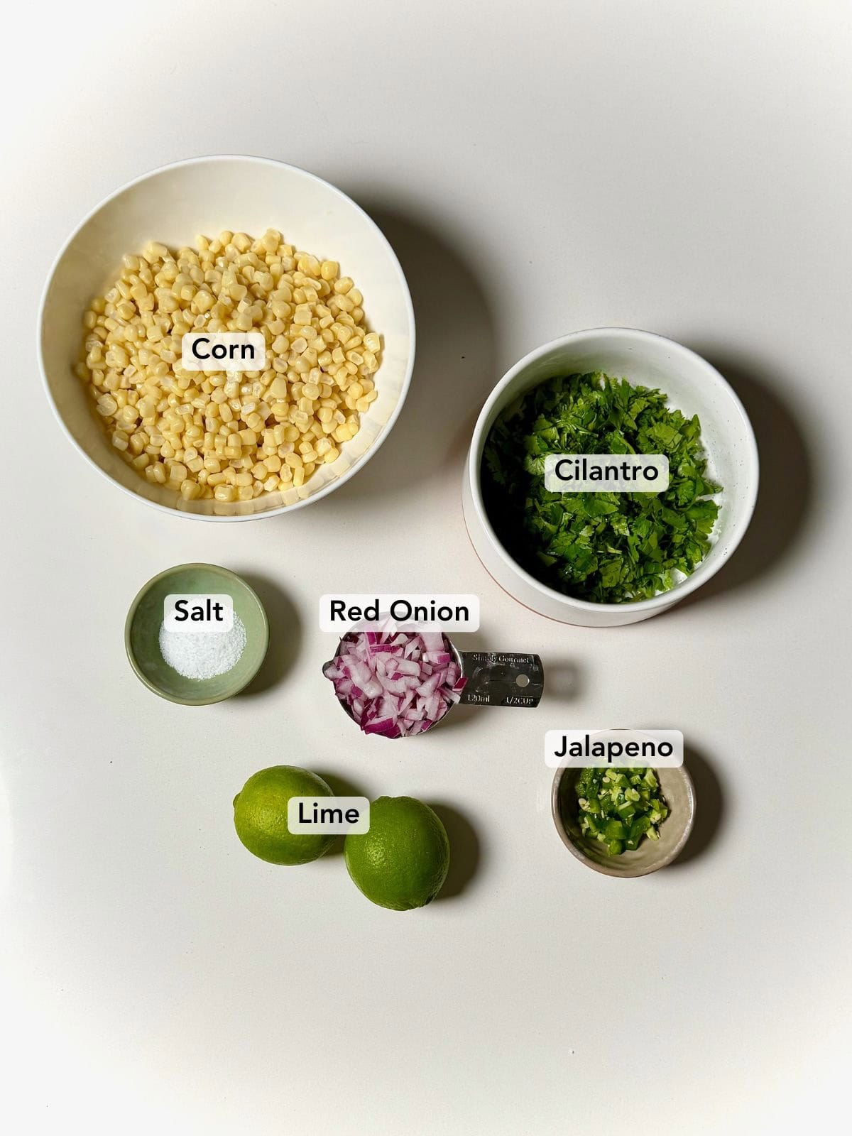 Ingredients for chipotle copycat corn salsa including corn, cilantro, red onion, lime, jalapeno, and salt.