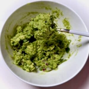 Chipotle copycat guacamole in bowl on spoon.