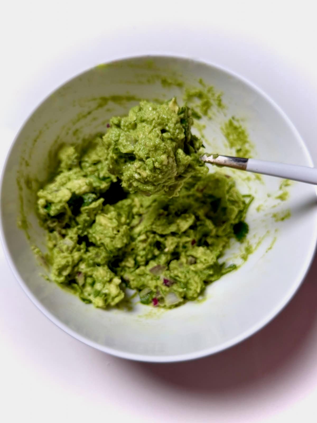 Chipotle copycat guacamole in bowl on spoon.
