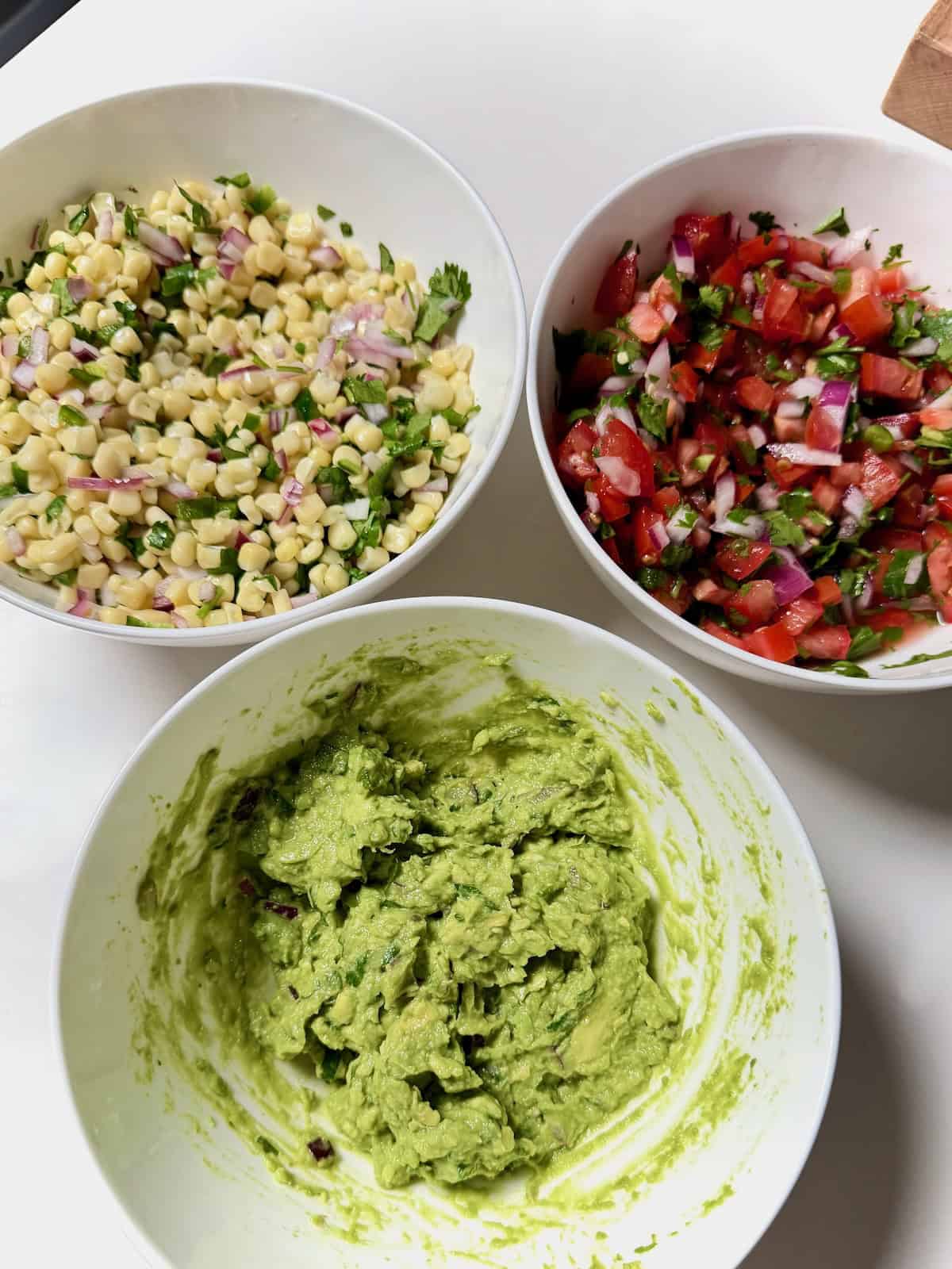 Chipotle copycat corn salsa, fresh tomato salsa, and guacamole.
