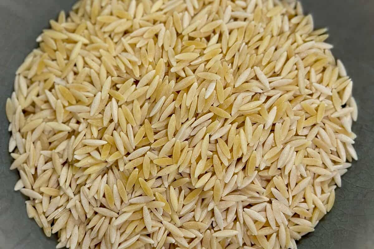 A grey bowl of uncooked orzo