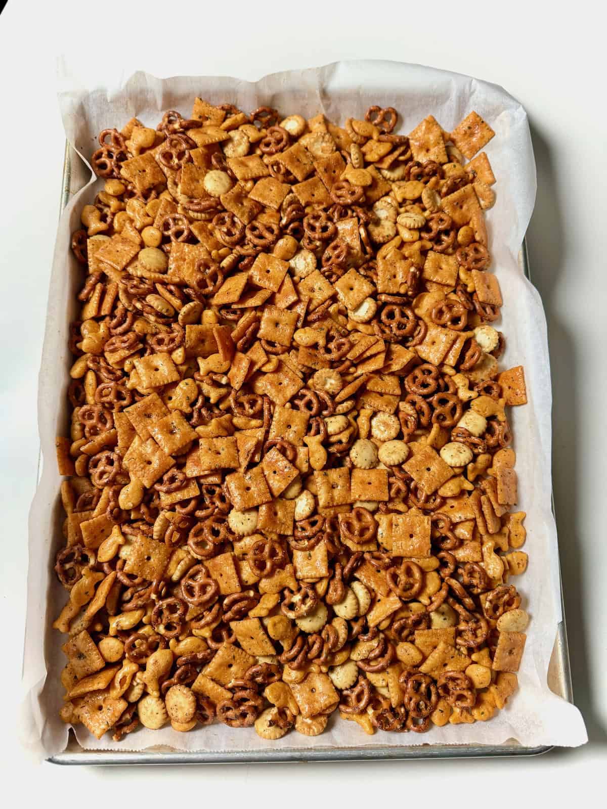 Homemade ranch cheez-it snack mix on a parchment-lined baking sheet.