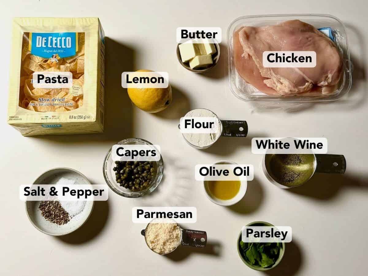 Ingredients for chicken piccata including chicken breasts, lemon, capers, and white wine.