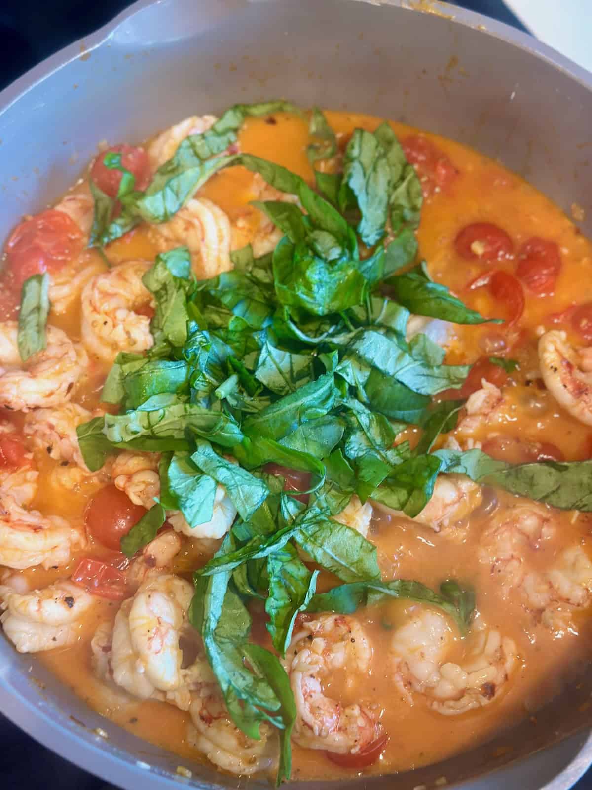 Fresh basil added to the shrimp and tomato sauce for Tomato Basil Shrimp Pasta.