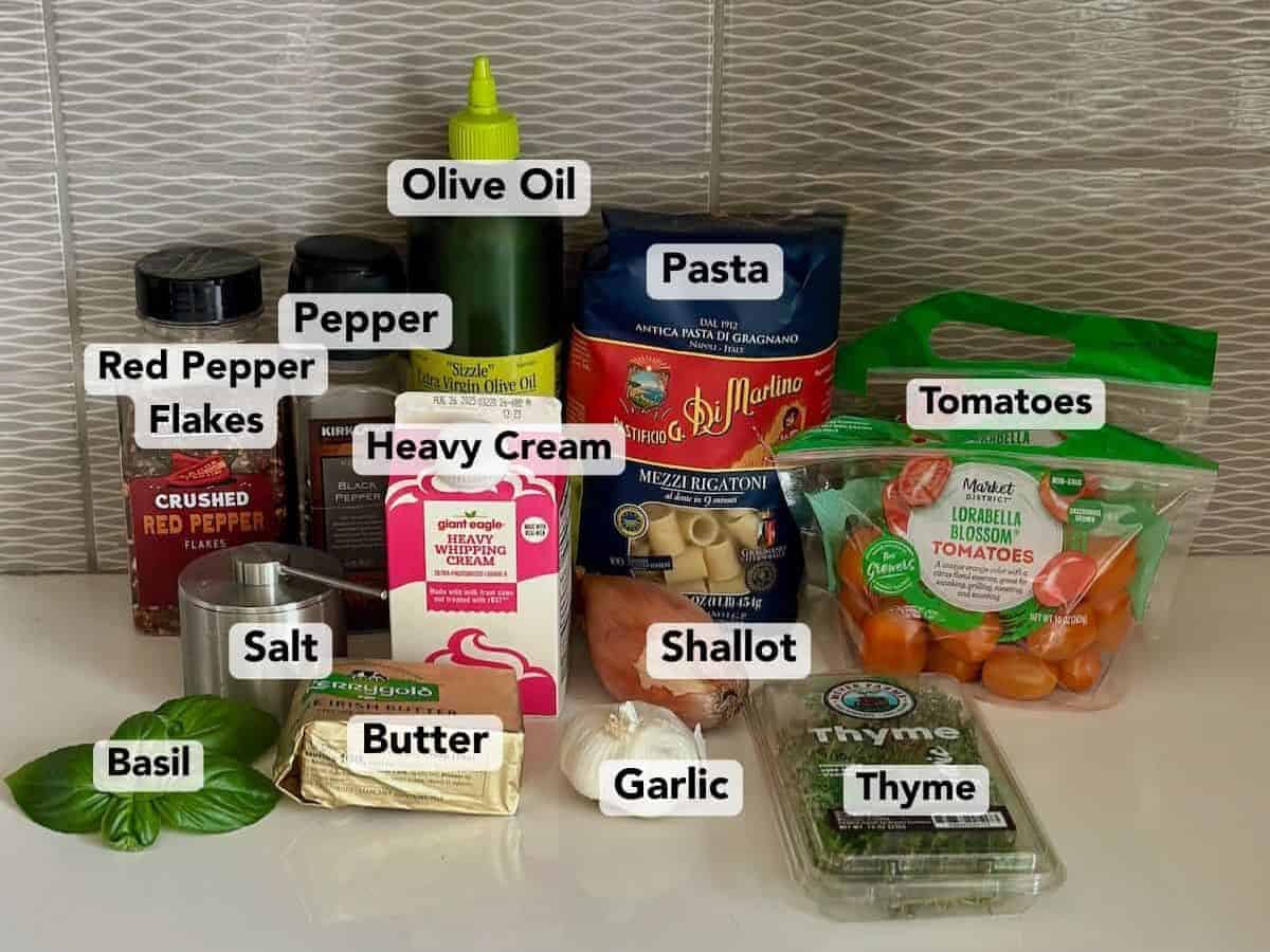 Ingredients for creamy orange tomato pasta with labels.