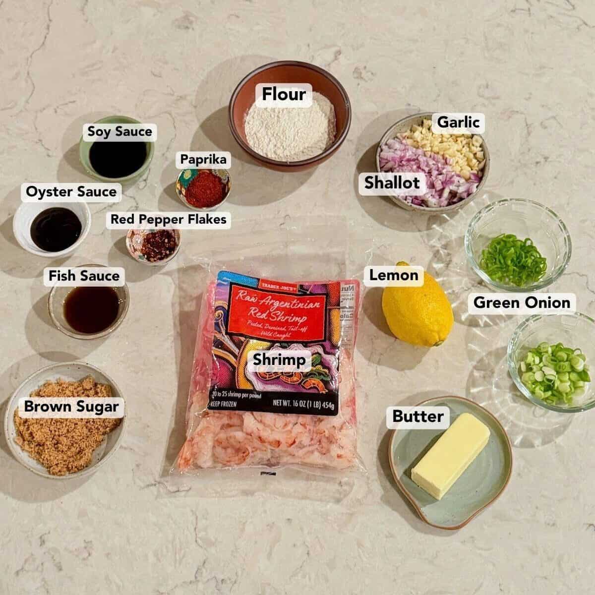 Ingredients for Hawaiian garlic shrimp are arranged on a light stone countertop.