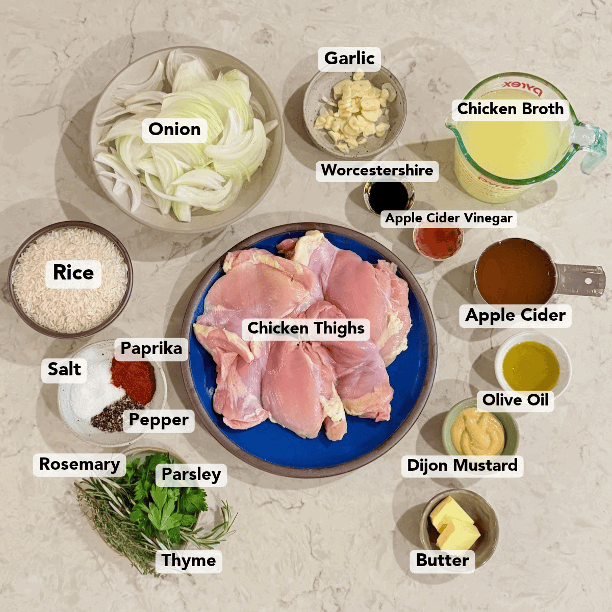Ingredients for apple cider braised chicken and rice arranged on a countertop.